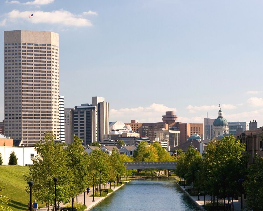 view of downtown Indianapolis from a canal, five best indianapolis suburbs for families